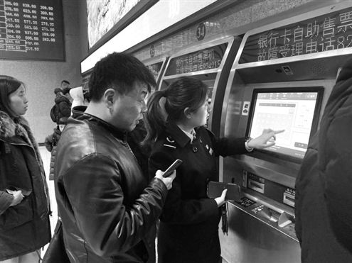 工作人员现场引导乘客使用电子客票